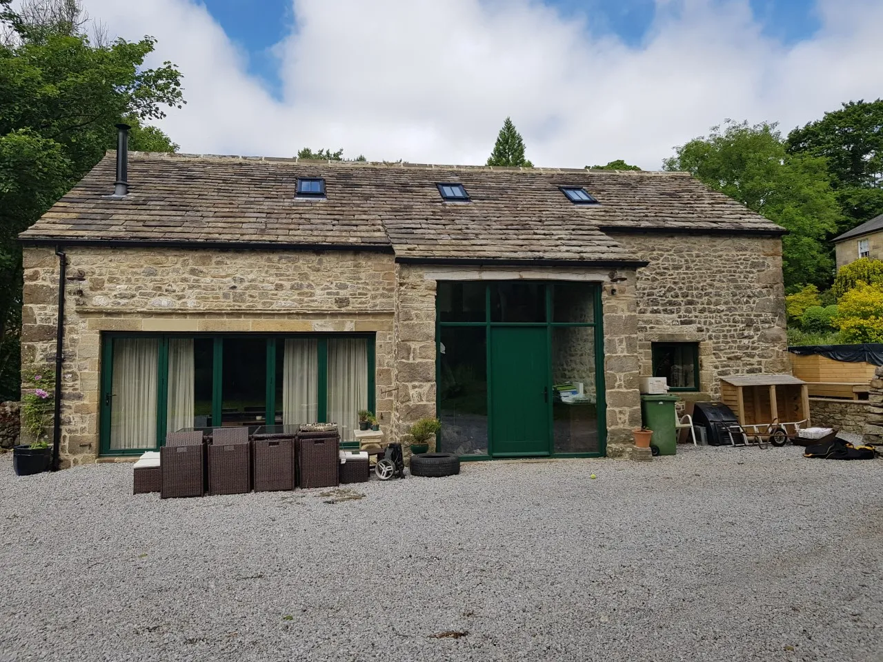 a stone building with a green door and windows