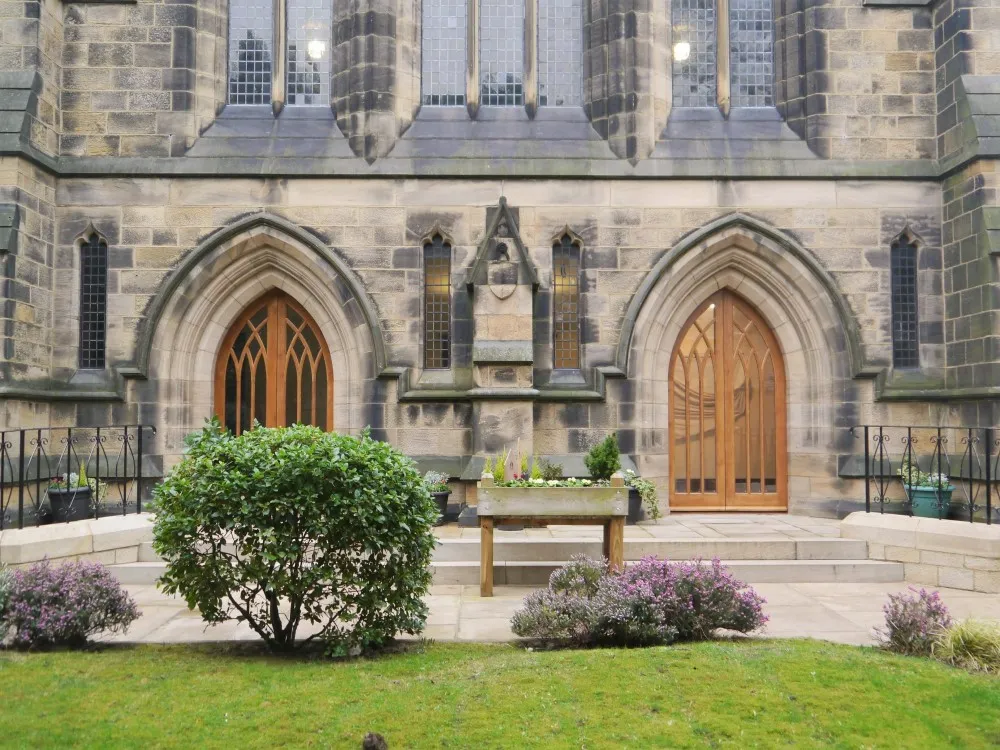 a stone building with two doors and a bench in front of it